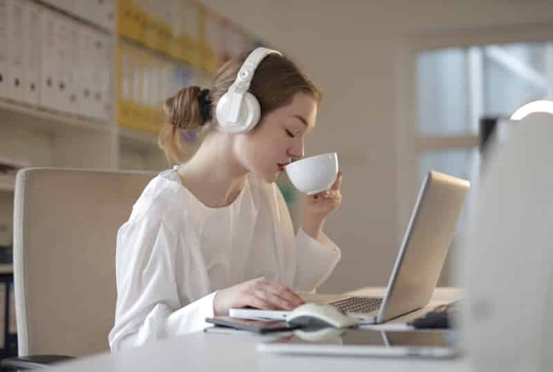 Woman Listening to Music while Drinking Coffee and Working